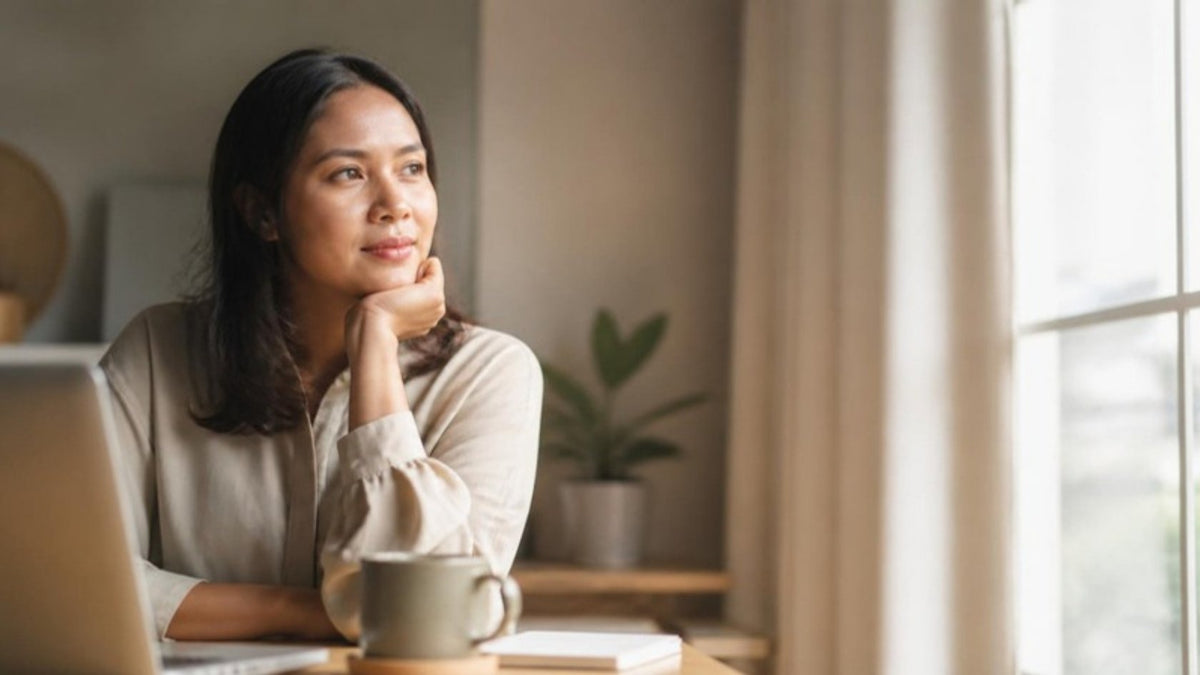Malaysian woman at desk resting her chin on her hand - always tired fatigue in women