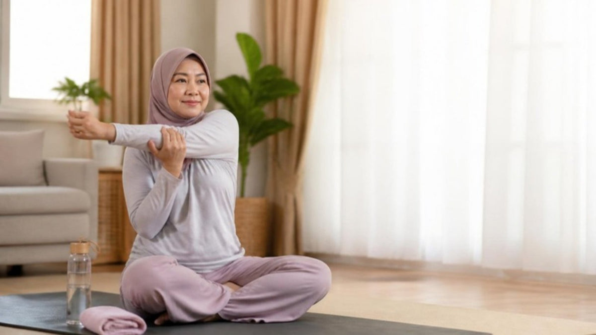 Malaysian woman doing a gentle morning yoga stretch at home - natural perimenopause symptoms relief